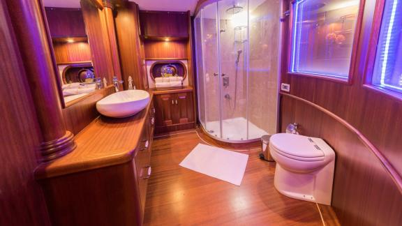 Spacious bathroom with shower and elegant wood paneling on the Halcon Del Mar.